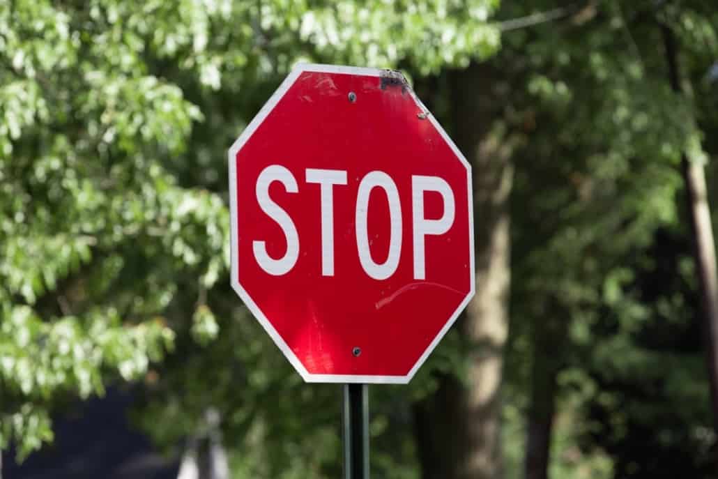 stop sign on a country road trees